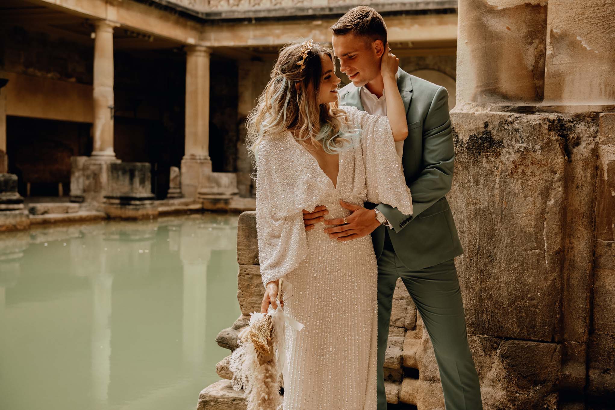 Wedding couple beside a column at the Roman Baths