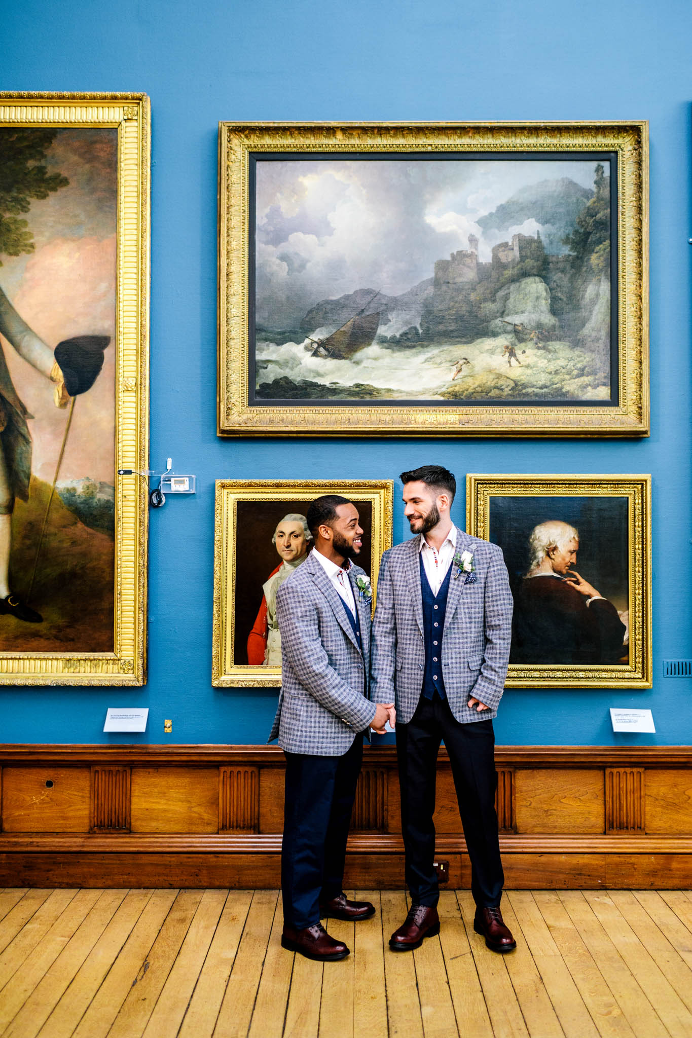 Wedding couple stand in front of artwork at the Victoria Art Gallery