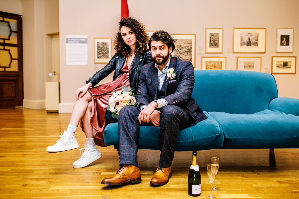 Wedding couple seated on blue sofa in Lower Gallery