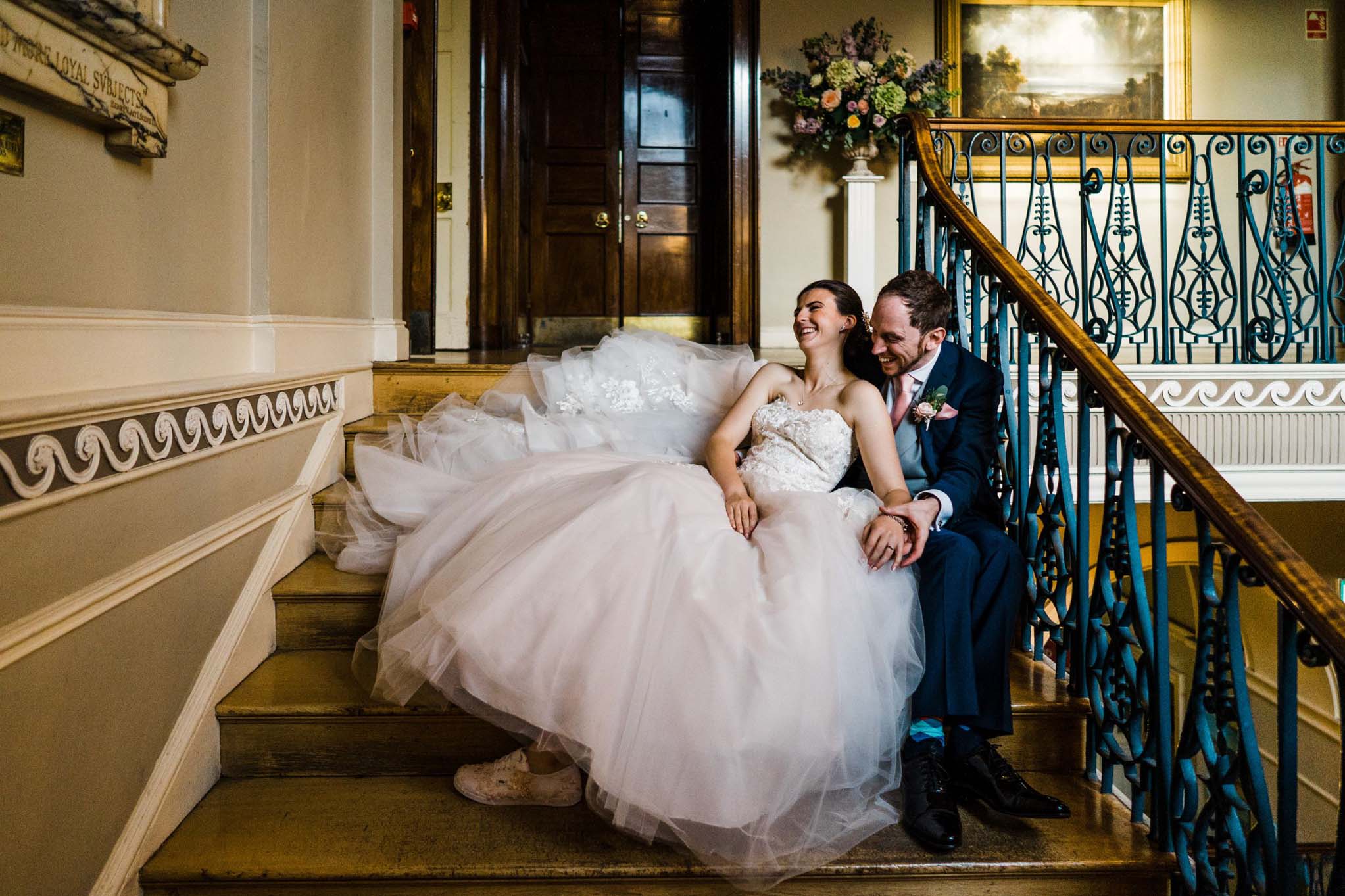 Wedding couple seated on the stairs at the Guildhall