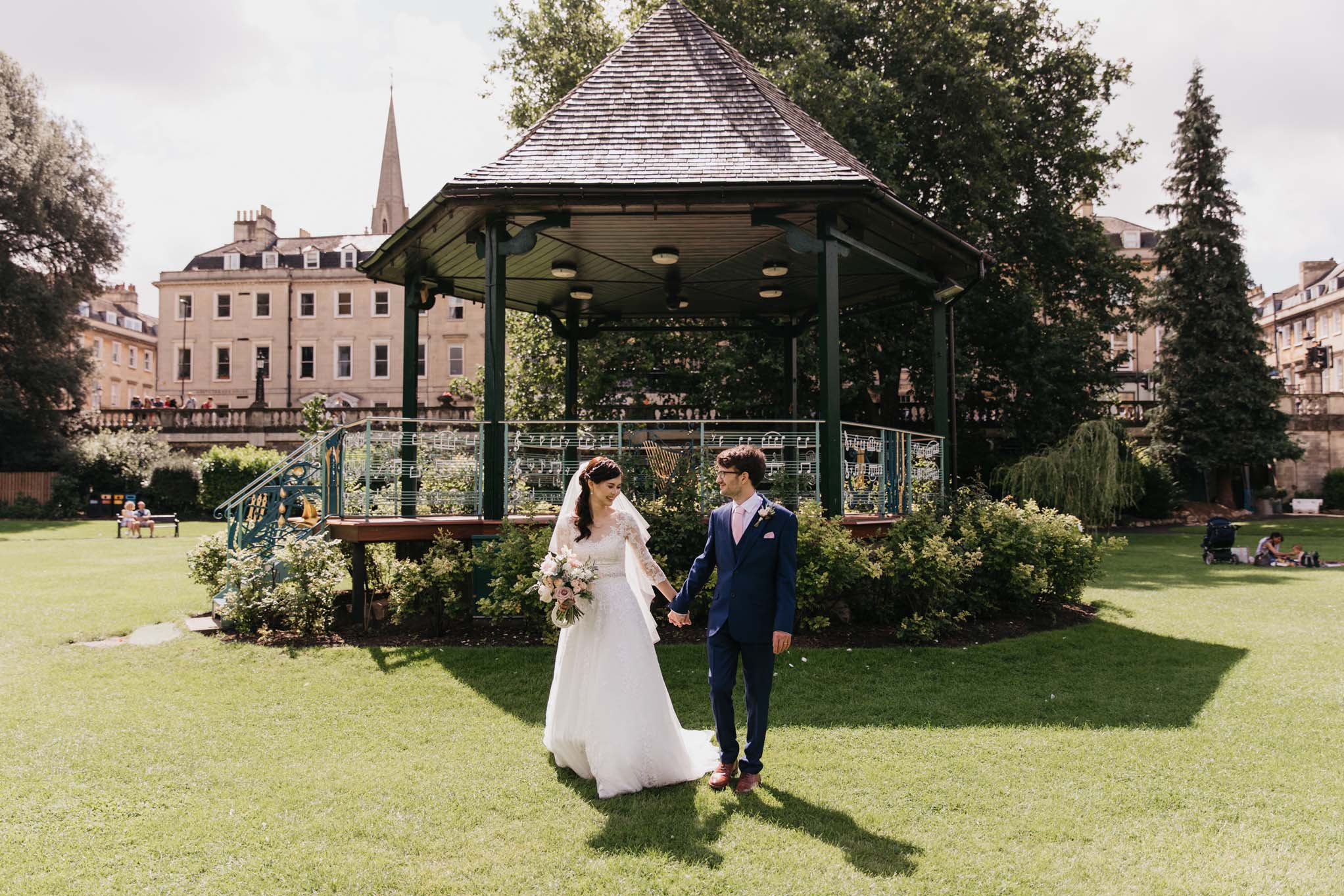 Couple walk away from bandstand, Parade Gardens