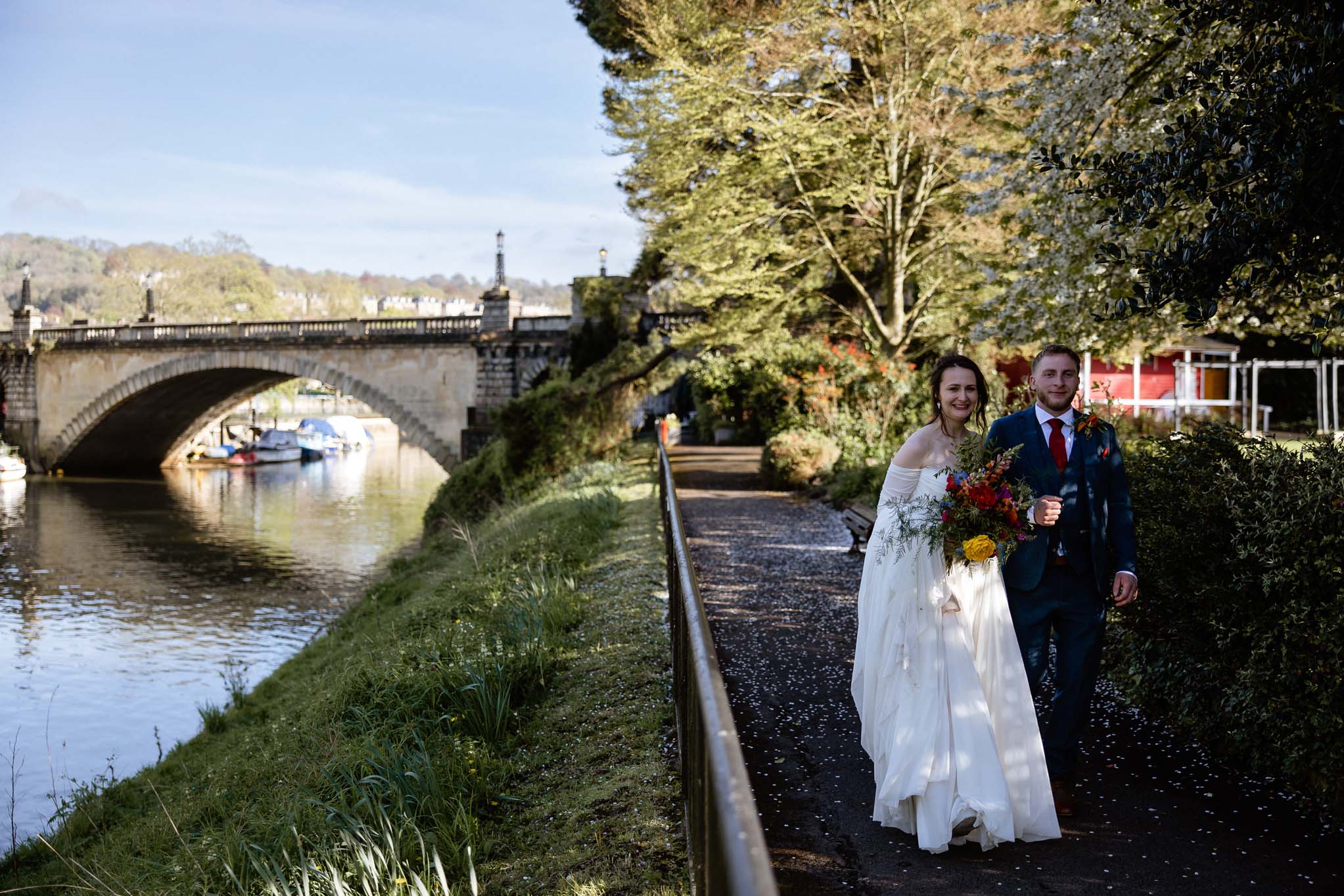 Wedding couple walk beside the river, Parade Gardens