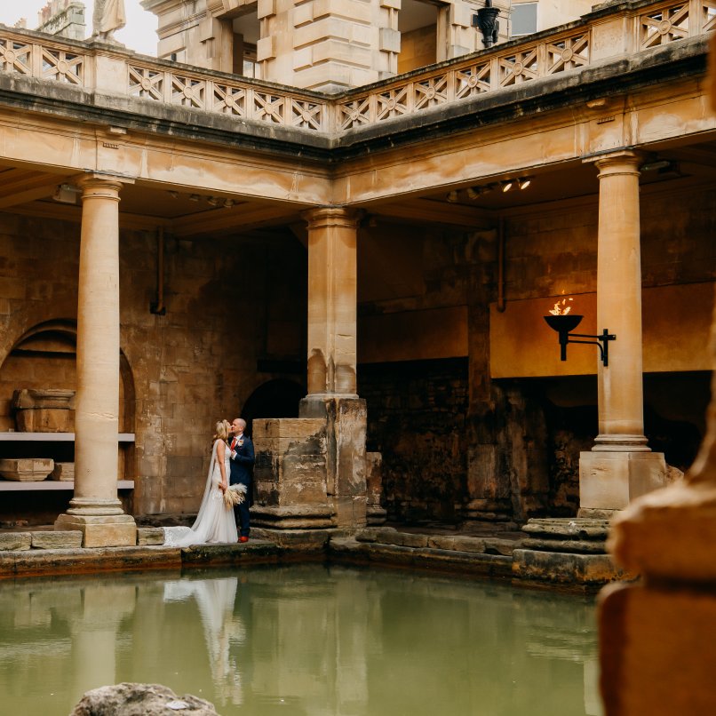 Wedding couple embrace beside the Great Bath, Emma-Jane Lewis